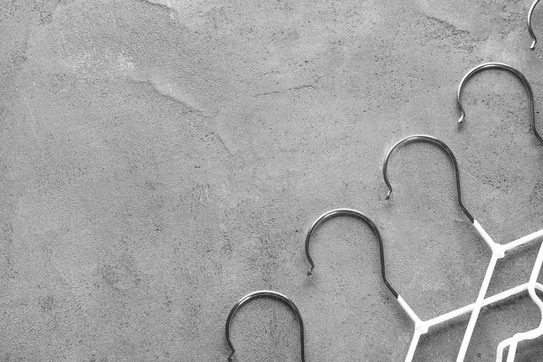 Many clothes hangers on grey background