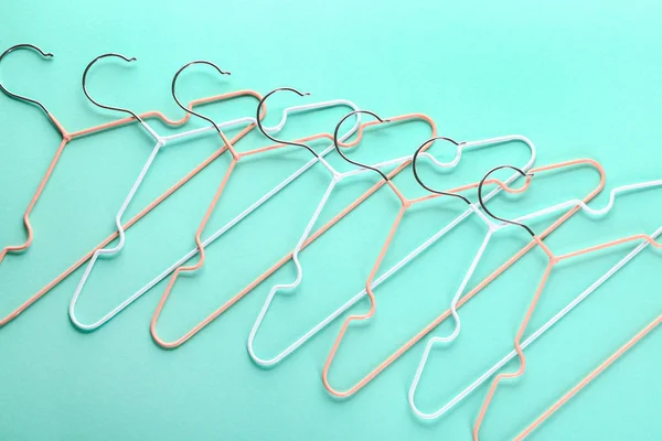 Many clothes hangers on color background