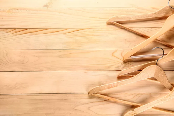 Много вешалок для одежды на деревянном фоне — стоковое фото