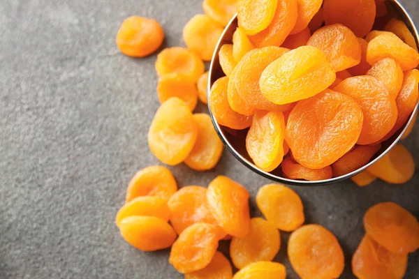 Bowl with dried apricots on grey background — Stock Photo, Image