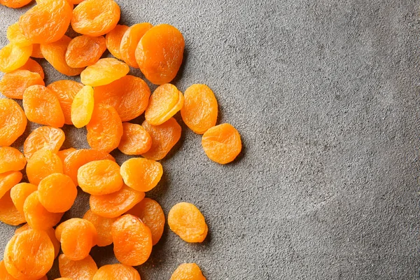 Tasty dried apricots on grey background — Stock Photo, Image