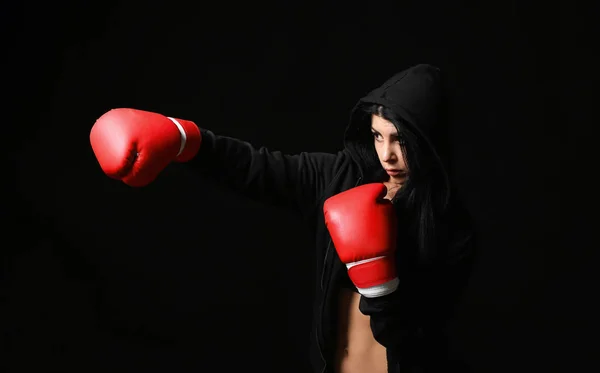 Sporty female boxer on dark background