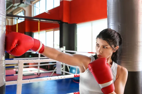 Entrenamiento de boxeador femenino con saco de boxeo en gimnasio — Foto de Stock