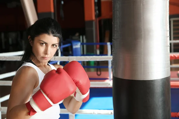 Entrenamiento de boxeador femenino con saco de boxeo en gimnasio —  Fotos de Stock