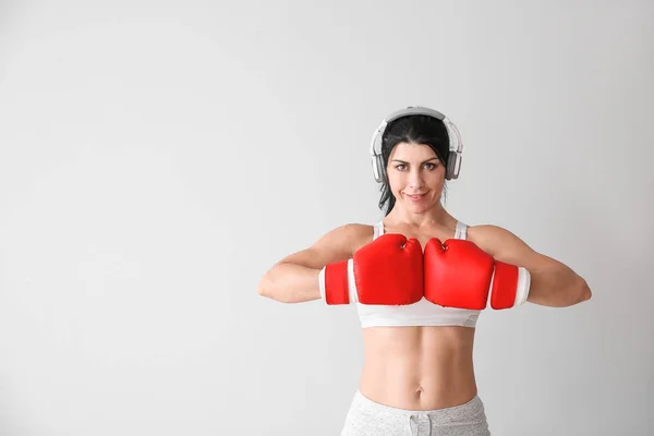 Boxeador deportivo femenino con auriculares sobre fondo blanco —  Fotos de Stock