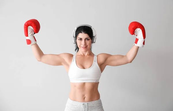 Boxeador deportivo femenino con auriculares sobre fondo blanco — Foto de Stock