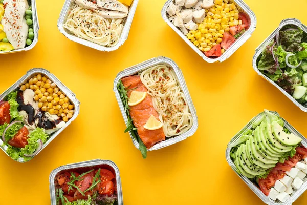 Many containers with delicious food on color background — Stock Photo, Image