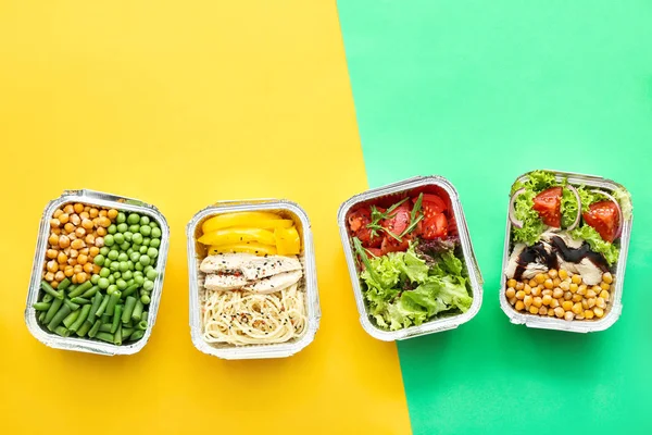 Veel containers met heerlijk eten op kleur achtergrond — Stockfoto