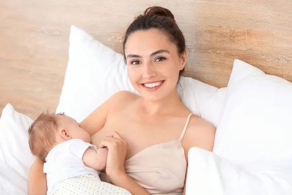 Young woman breastfeeding her baby at home — Stock Photo, Image