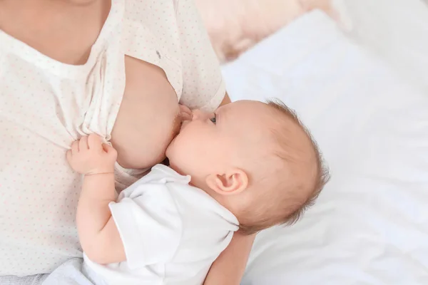 Mujer joven amamantando a su bebé en casa —  Fotos de Stock