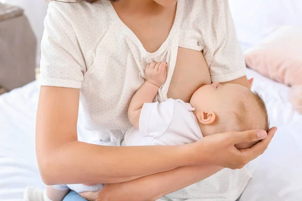 Jonge vrouw borstvoeding haar baby thuis — Stockfoto
