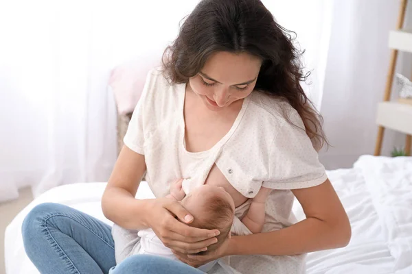 Young woman breastfeeding her baby at home — Stock Photo, Image