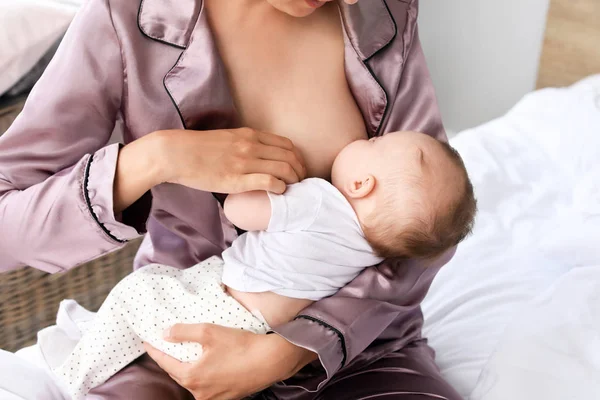 Young woman breastfeeding her baby at home — Stock Photo, Image