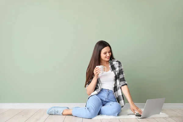 Kobieta blogger z laptopem siedzi w pobliżu koloru ściany — Zdjęcie stockowe