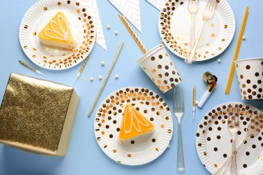 Renkli arka planda pasta, tabak ve bardak ile doğum günü hediyesi