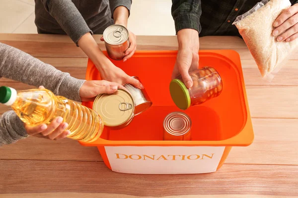 Volontärer sätta donation mat i rutan vid bordet — Stockfoto