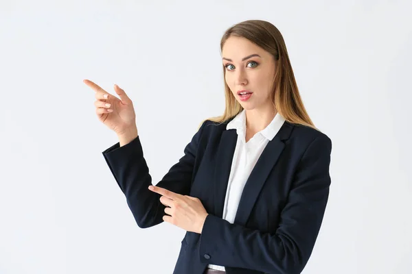 Hermosa joven empresaria señalando algo sobre fondo blanco —  Fotos de Stock