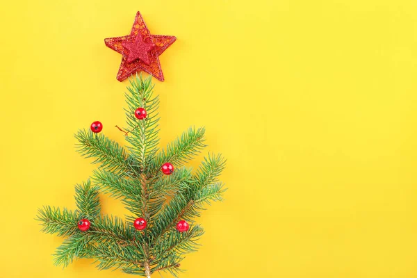 Fir tree branches with Christmas decor on color background — Stock Photo, Image