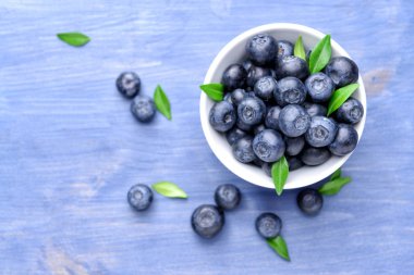 Ahşap arka plan üzerinde olgun yaban mersini ile Bowl