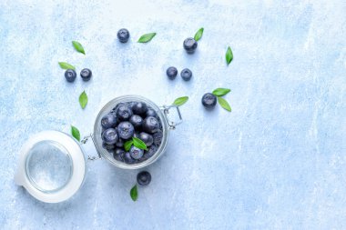 Açık arka planda olgun yaban mersini ile Kavanoz