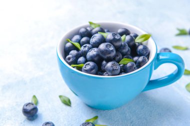 Açık arka planda olgun yaban mersini ile Fincan