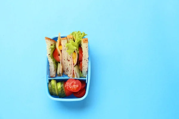 रंग पृष्ठभूमि पर स्वादिष्ट भोजन के साथ स्कूल लंच बॉक्स — स्टॉक फ़ोटो, इमेज