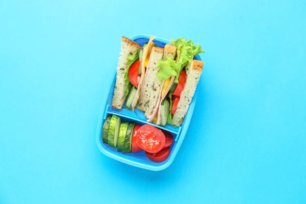 School lunch box with tasty food on color background