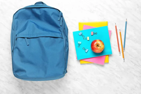 Plecak z przyborów szkolnych na jasnym tle — Zdjęcie stockowe