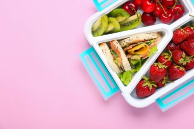 Renkli arka planda lezzetli gıda ile Okul öğle yemeği kutusu