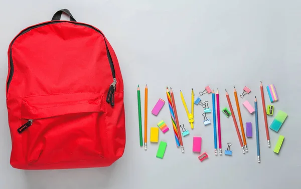 Mochila con material escolar sobre fondo gris —  Fotos de Stock