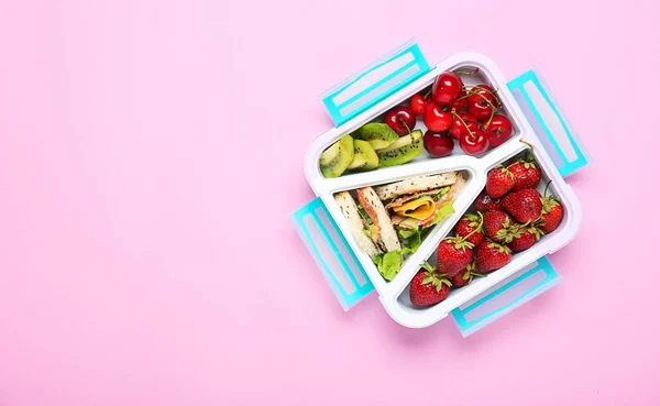 Schoollunchbox met lekker eten op kleur achtergrond — Stockfoto