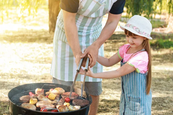 Kleines Mädchen mit Vater kocht leckeres Essen auf Grill im Freien — Stockfoto