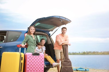Tatil beldesinde araba yakınında bagaj ile mutlu aile
