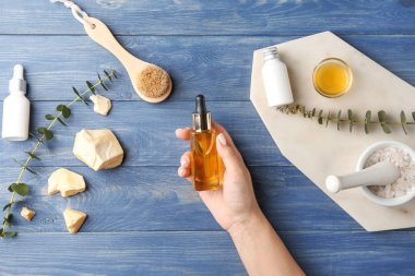 Ahşap masada spa prosedürleri için kozmetik ile Kadın