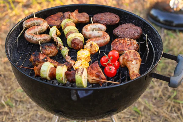 Cozinhar de comida saborosa em churrasqueira ao ar livre — Fotografia de Stock
