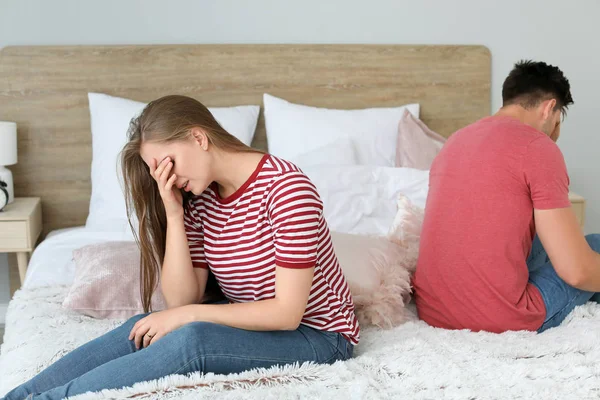 Quarreled couple sitting on bed at home — Stock Photo, Image