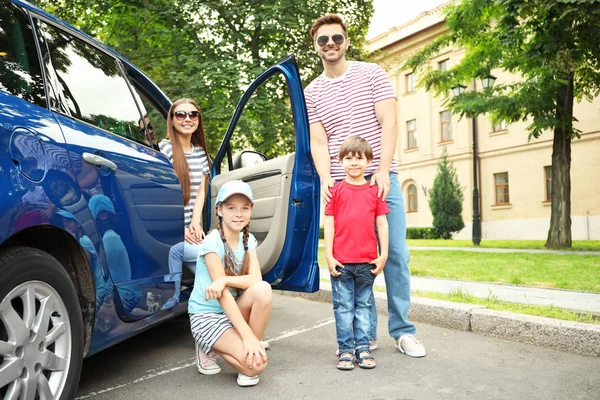 Gelukkige familie in de buurt van auto buiten — Stockfoto
