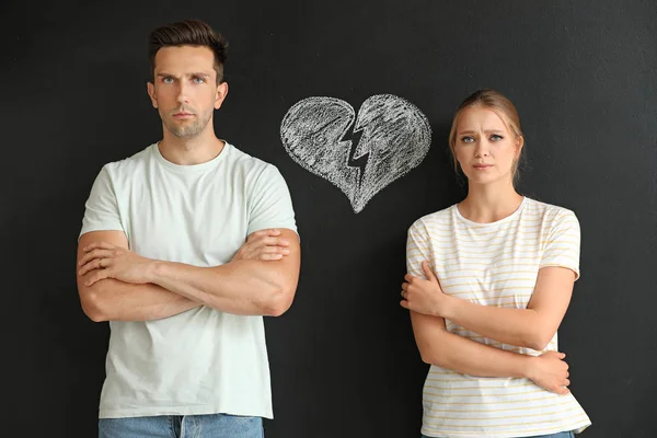 Quarreled couple and drawing of broken heart on dark background. Concept of divorce — Stock Photo, Image