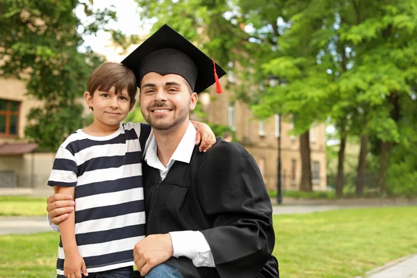 Man with his little son on graduation day — Stock Photo, Image