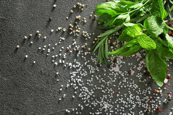 Different herbs, salt and spices on grey background