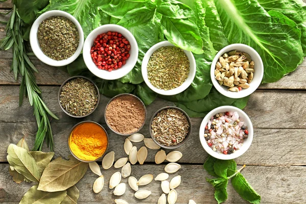 Different herbs and spices on wooden background — Stock Photo, Image