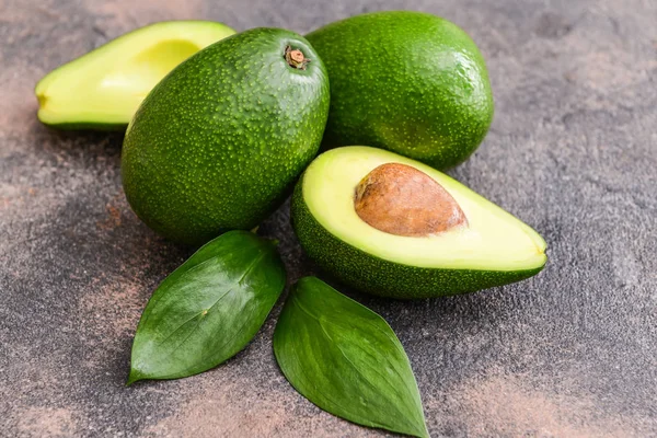 Aguacates maduros frescos sobre fondo gris —  Fotos de Stock