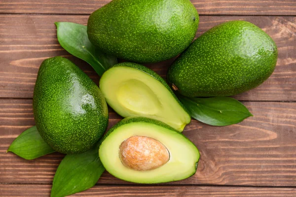 Aguacates maduros frescos sobre fondo de madera — Foto de Stock