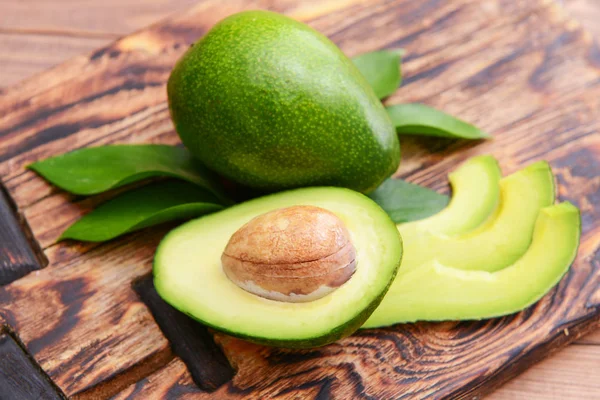 Verse rijpe avocado's op houten plank — Stockfoto