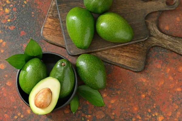 Aguacates frescos maduros con tablas sobre fondo de color — Foto de Stock