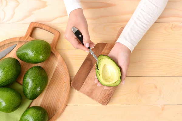 Woman with fresh avocados at table — Stock Photo, Image