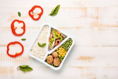 Beyaz ahşap masada lezzetli yemek ile Okul öğle yemeği kutusu