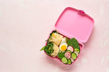 Renkli arka planda lezzetli gıda ile Okul öğle yemeği kutusu