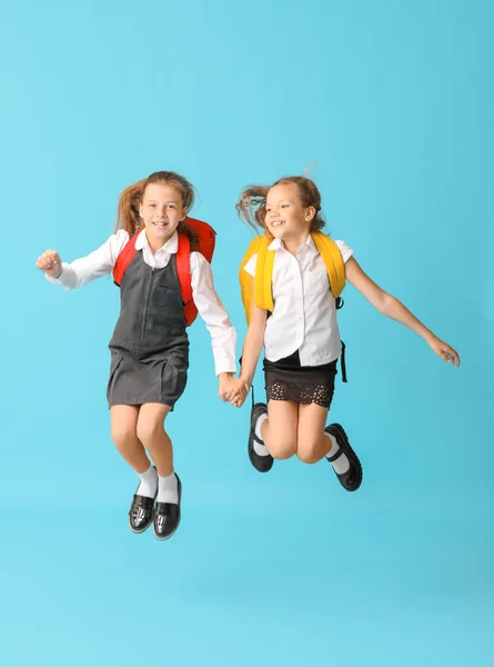 Carino salto studentesse su sfondo di colore — Foto Stock