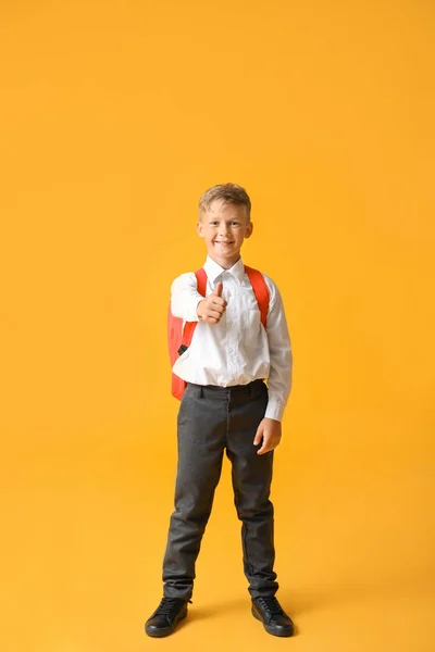 Cute little schoolboy showing thumb-up on color background — Stock Photo, Image